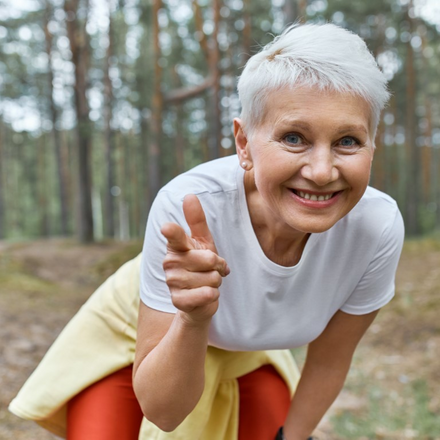 outdoor-view-energetic-joyful-female-pensioner-sports-clothes-leaning-forward-smiling-pointing-fore-finger-front.jpg